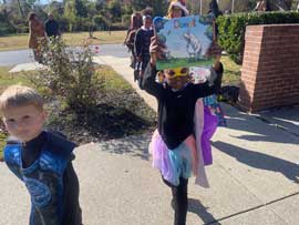Students dressed in costume, one holding up a book called Donut.