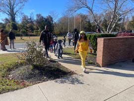 Adults walking with students in the parade