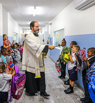 Families greeted by Rev. Baer coming to school